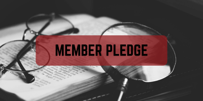 Black and White image of a book with glasses and a magnifying glass with text overlay that says Member Pledge